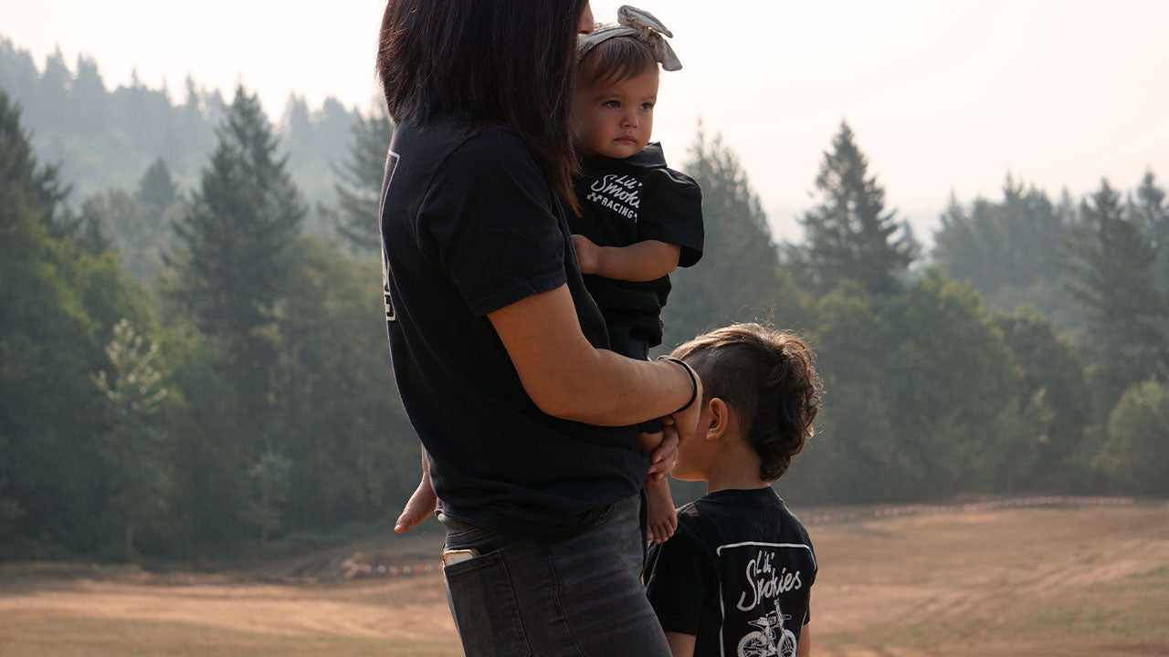 For the love of moto. A family at the racetrack wearing Lil' Smokies Racing apparel. LSR checkered motocross gear full family sizing. Motocross tee in black.