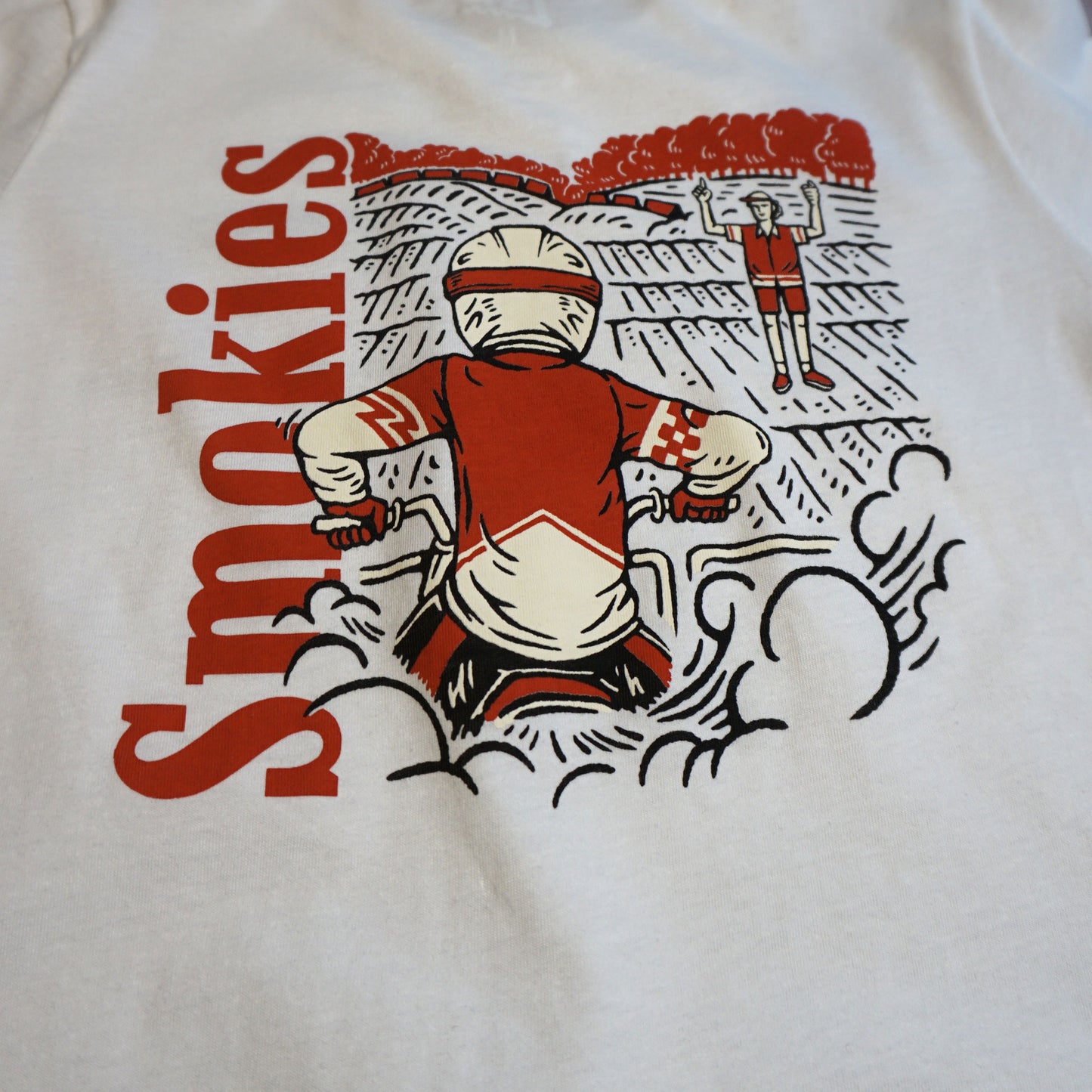 Close up image of the back of the tshirt. Focused on the dirt bike rider at the starting gate elbows up, waiting for the starter to drop the gate Image is in white and red water based ink.