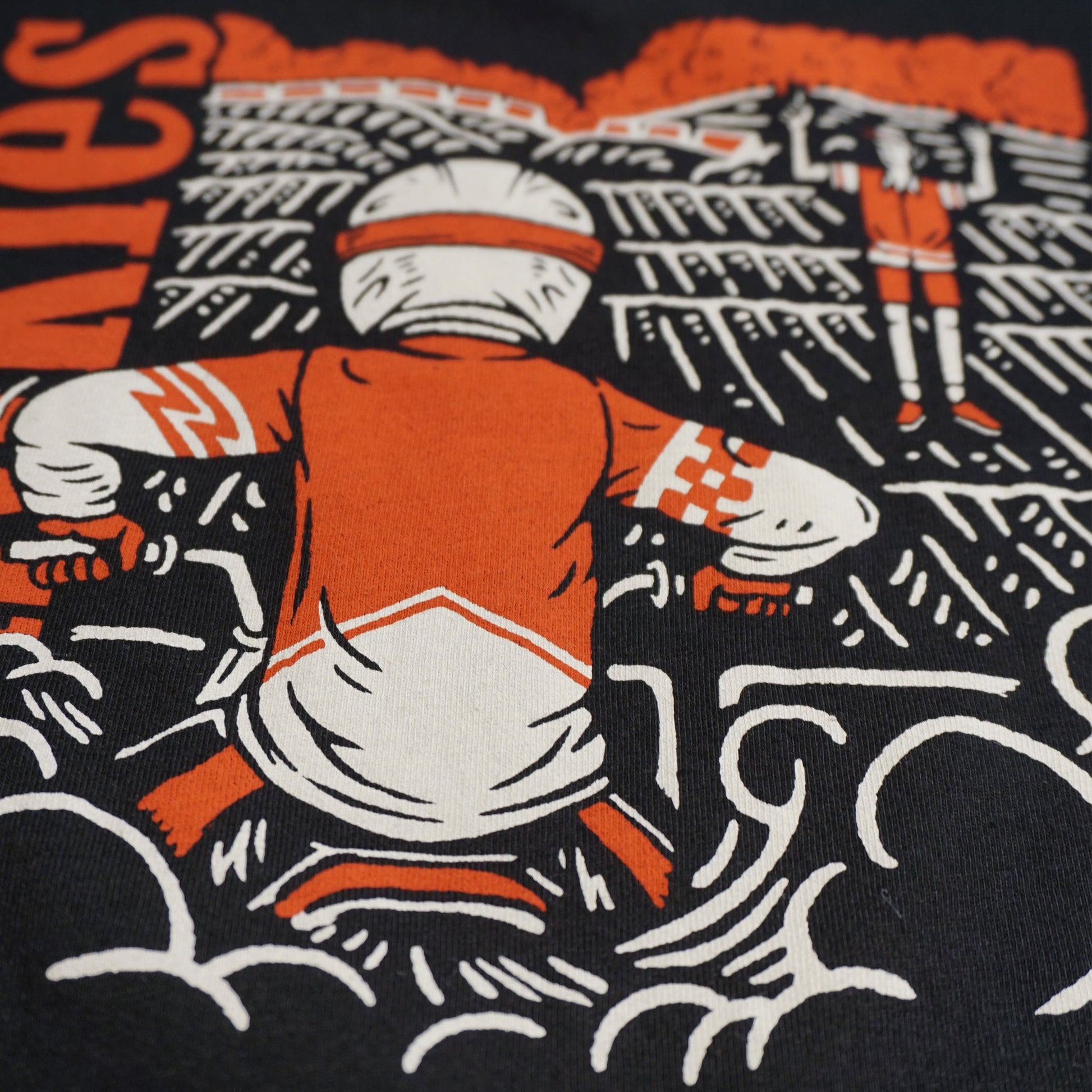 Close up image of the back of the tshirt. Focused on the dirt bike rider at the starting gate elbows up, waiting for the starter to drop the gate Image is in white and red water based ink.