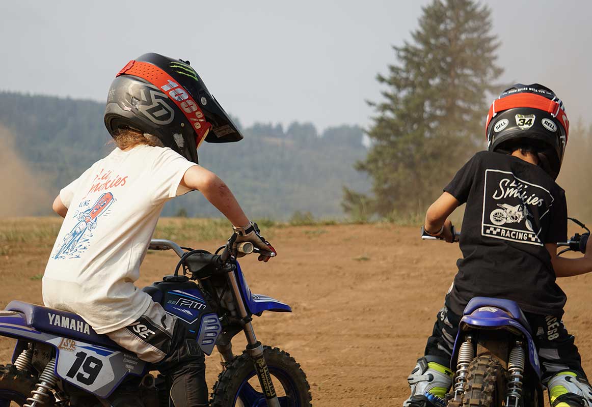 Quality moto gear, two youth motocross racers practicing. Featuring our lil smokies racing apparel while riding a yamaha pw 50. wearing motocross Alpine star boots, fasthouse helmets and Oakley Goggles. 