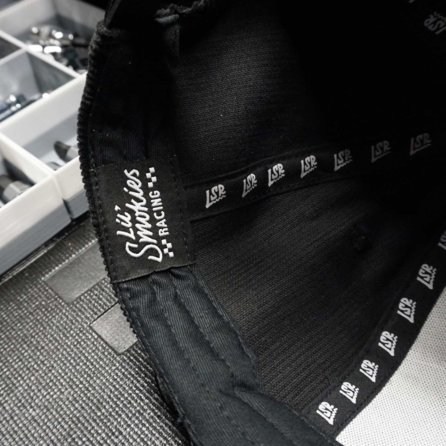 Close up image of the inside of the hat with the Lil Smokies Racing tagging and LSR repeated ribbon.