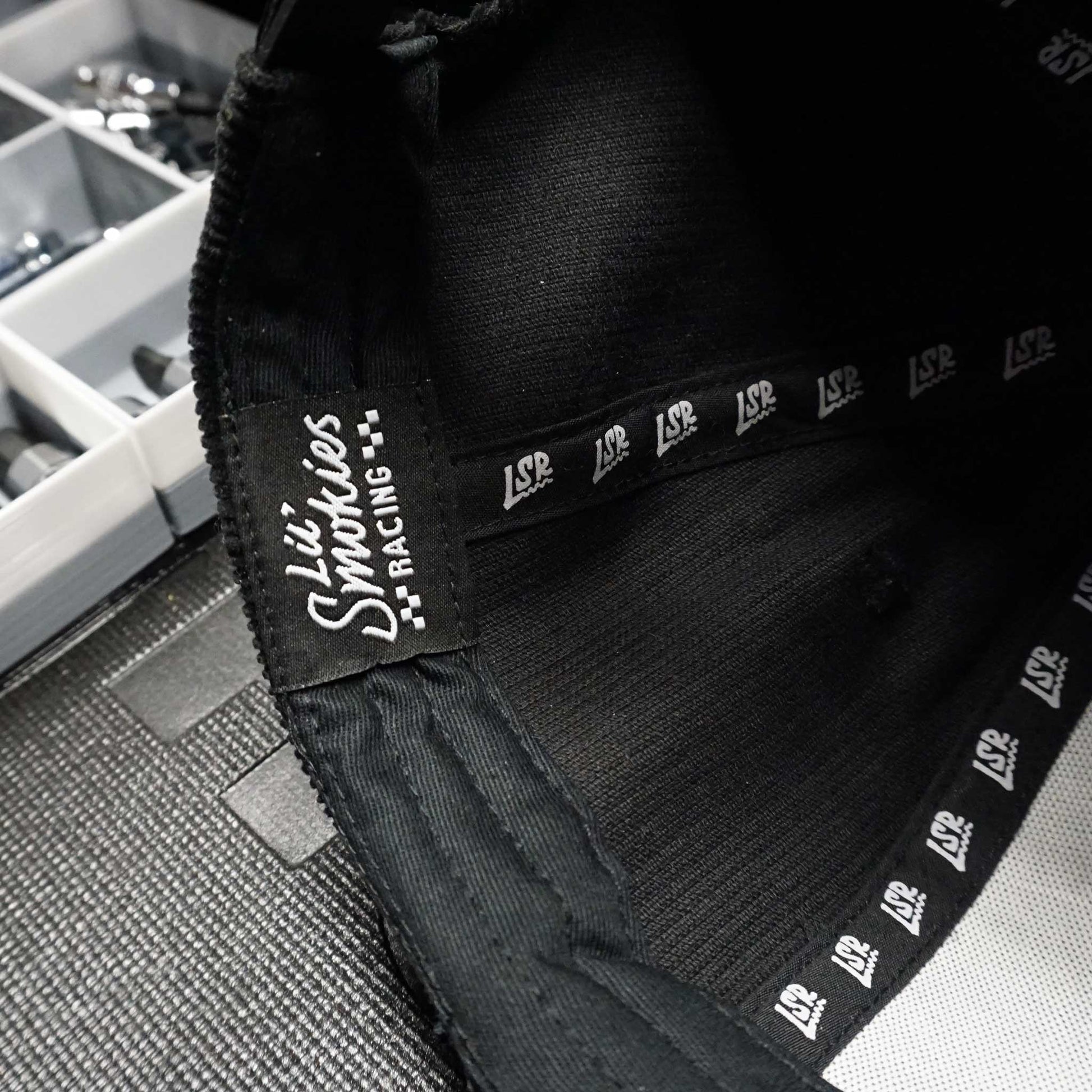 Close up image of the inside of the hat with the Lil Smokies Racing tagging and LSR repeated ribbon.