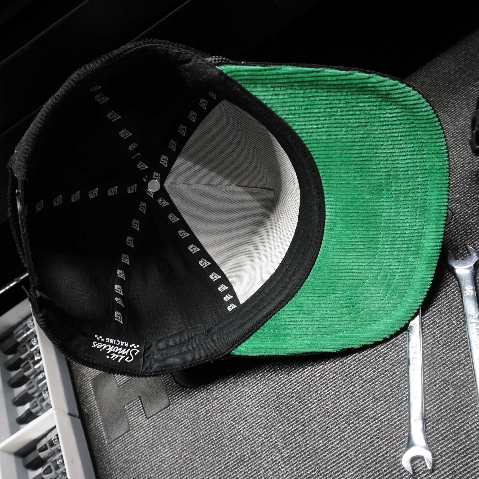 inside image of the hat with Lil Smokies Racing tagging and LSR repeated ribbon in the interior of the hat. Under the bill is green corduroy