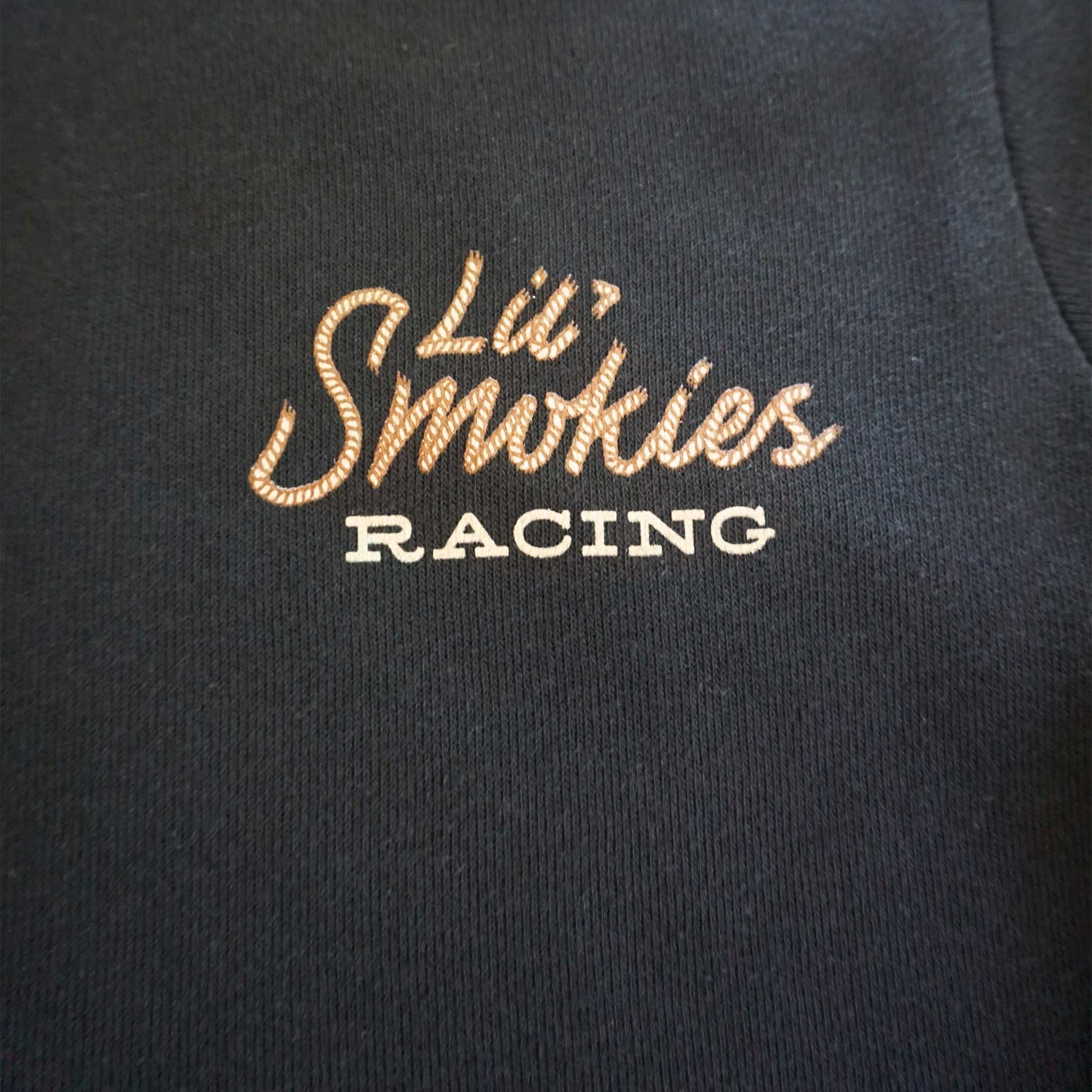 Close up image of the left front chest logo of Lil' Smokies racing in rope western font.